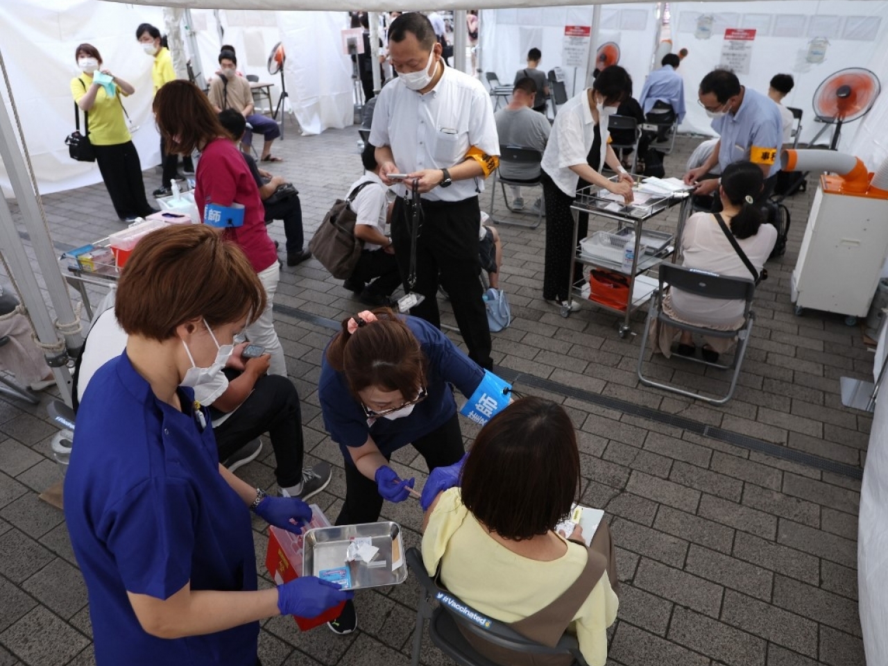 東京民眾在鐵路站外的臨時接種站注射新冠疫苗。（法新社資料圖片）