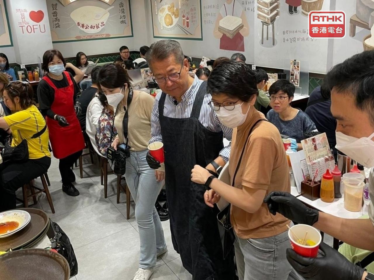 Financial chief Paul Chan marked the occasion by dressing as a waiter and serving siu mai and soy milk to diners at a Sham Shui Po restaurant. Photo: RTHK