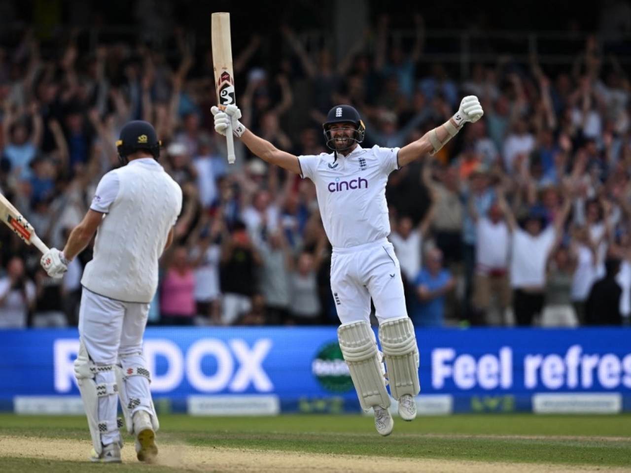 England's Mark Wood (right) celebrates with England's Chris Woakes (left) after Woakes hits a boundary to win the test. Photo: AFP