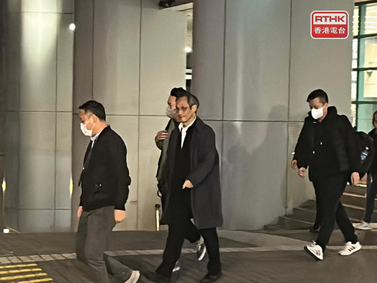 鍾庭耀(左二) 被國安處人員帶離辦公室，當局將調查他有否協助潛逃者。（林曉儀攝）