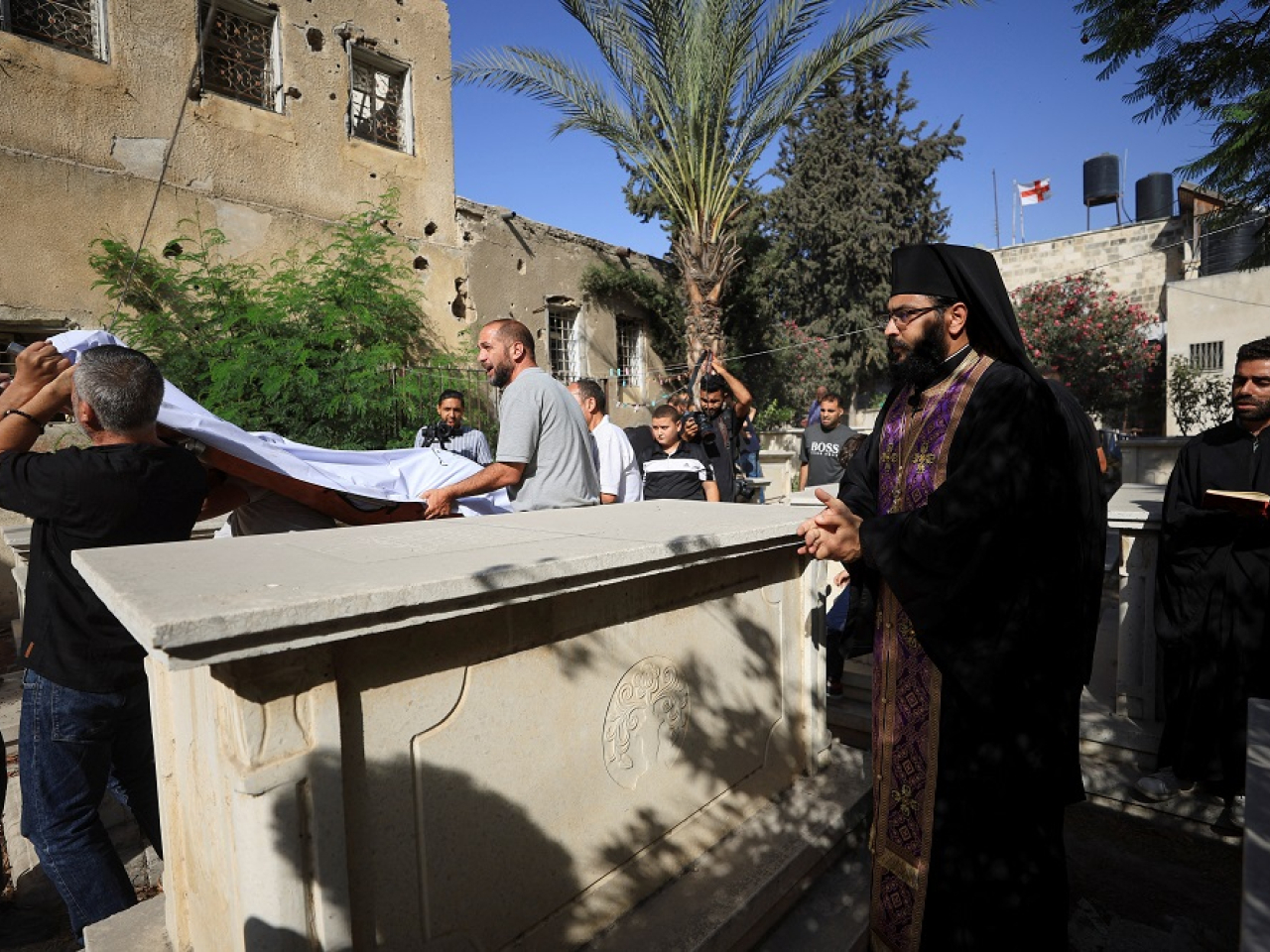 Mourners attend the burial of two Palestinian Christians killed in the Israeli strike on the Holy Family Church. Photo: Reuters