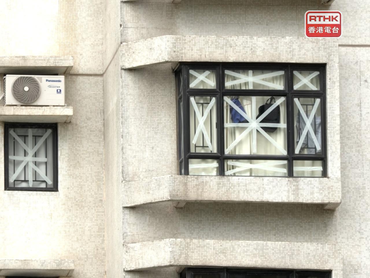 有杏花邨居民為窗門貼上防風膠紙。（孔令輝攝）