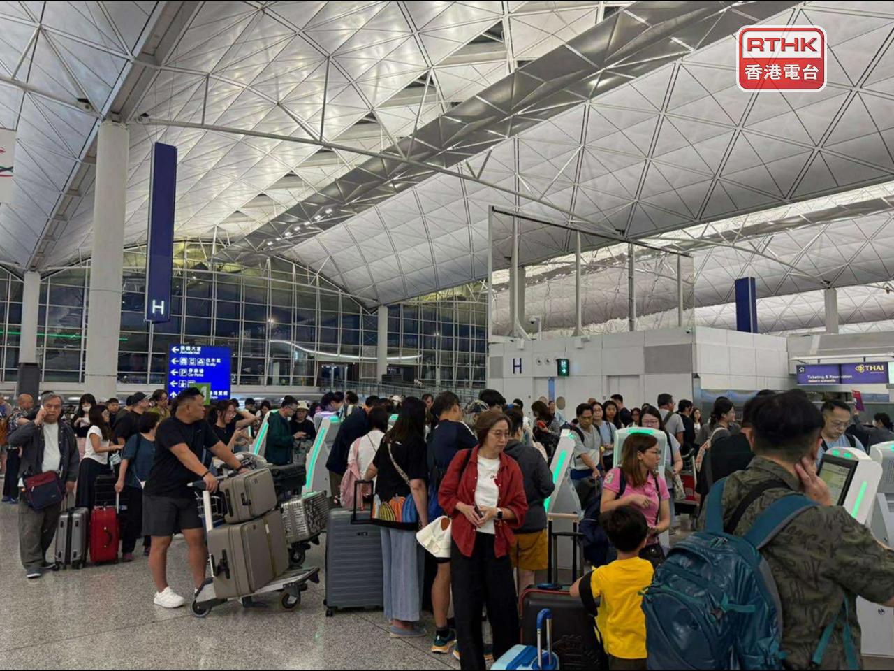 大批旅客早上到機場，辦理登機手續。（陳曉筠攝）