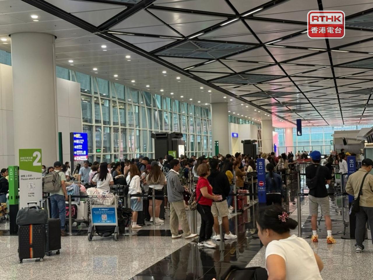 大批旅客早上到機場辦理登機手續。（陳曉筠攝）
