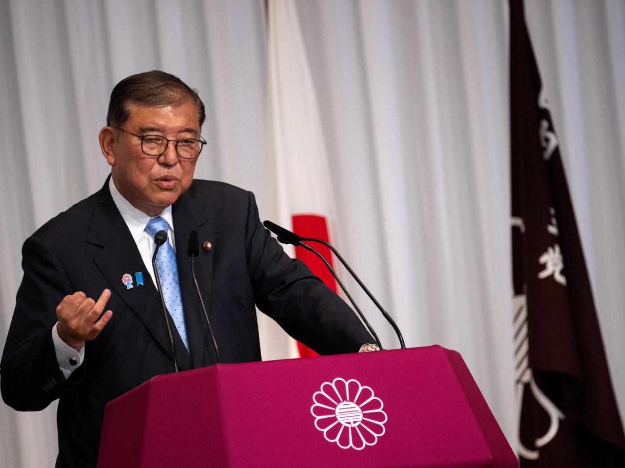 Shigeru Ishiba enumerates his reasons for staying on as Japan's prime minister at his party's headquarters a day after a trouncing in the elections. Photo: Reuters