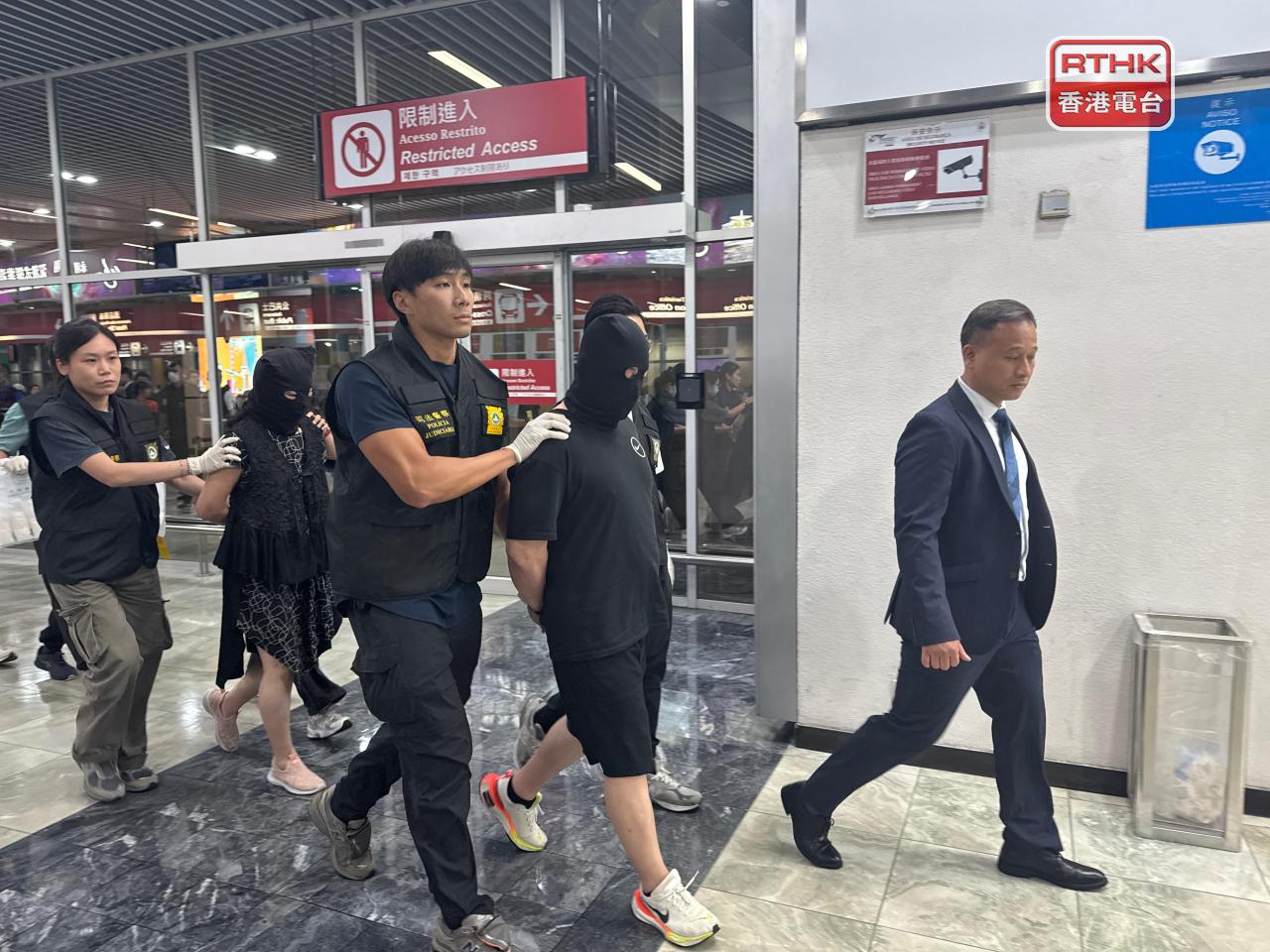 澳門司警傍晚從澳門國際機場帶走2名涉嫌販毒的港人。（鄭月明攝）