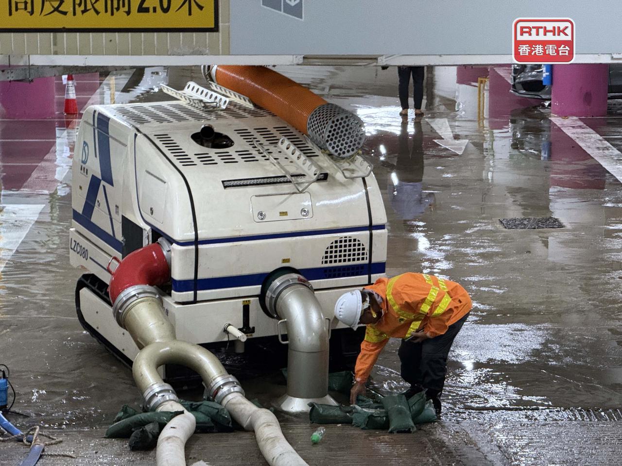 環翠邨商場停車場內，有渠務署人員用排水機械人抽走車場內的積水。（實習記者林藹晴攝）