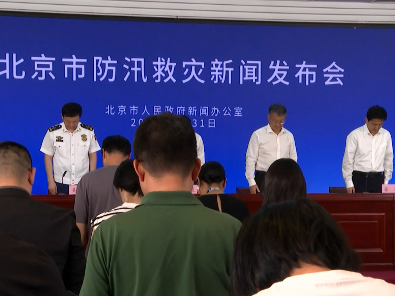 在記者會上，現場全體肅立默哀1分鐘。（央視截圖）