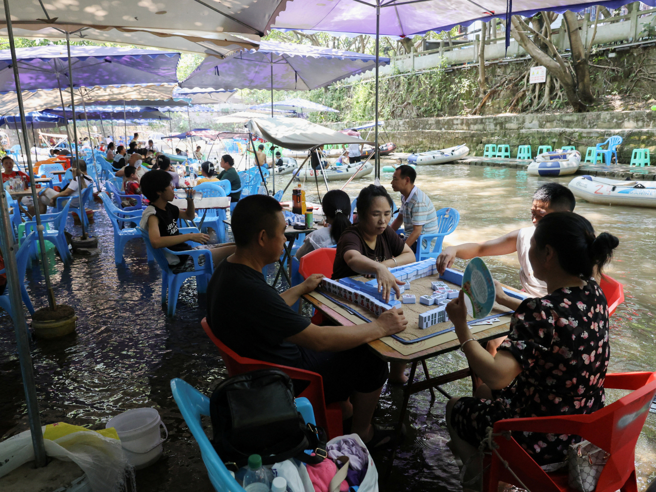 Chongqing residents play mahjong in the middle of a shallow river amid a red alert for heat in the ancient town of Pianyan. Photo: Reuters