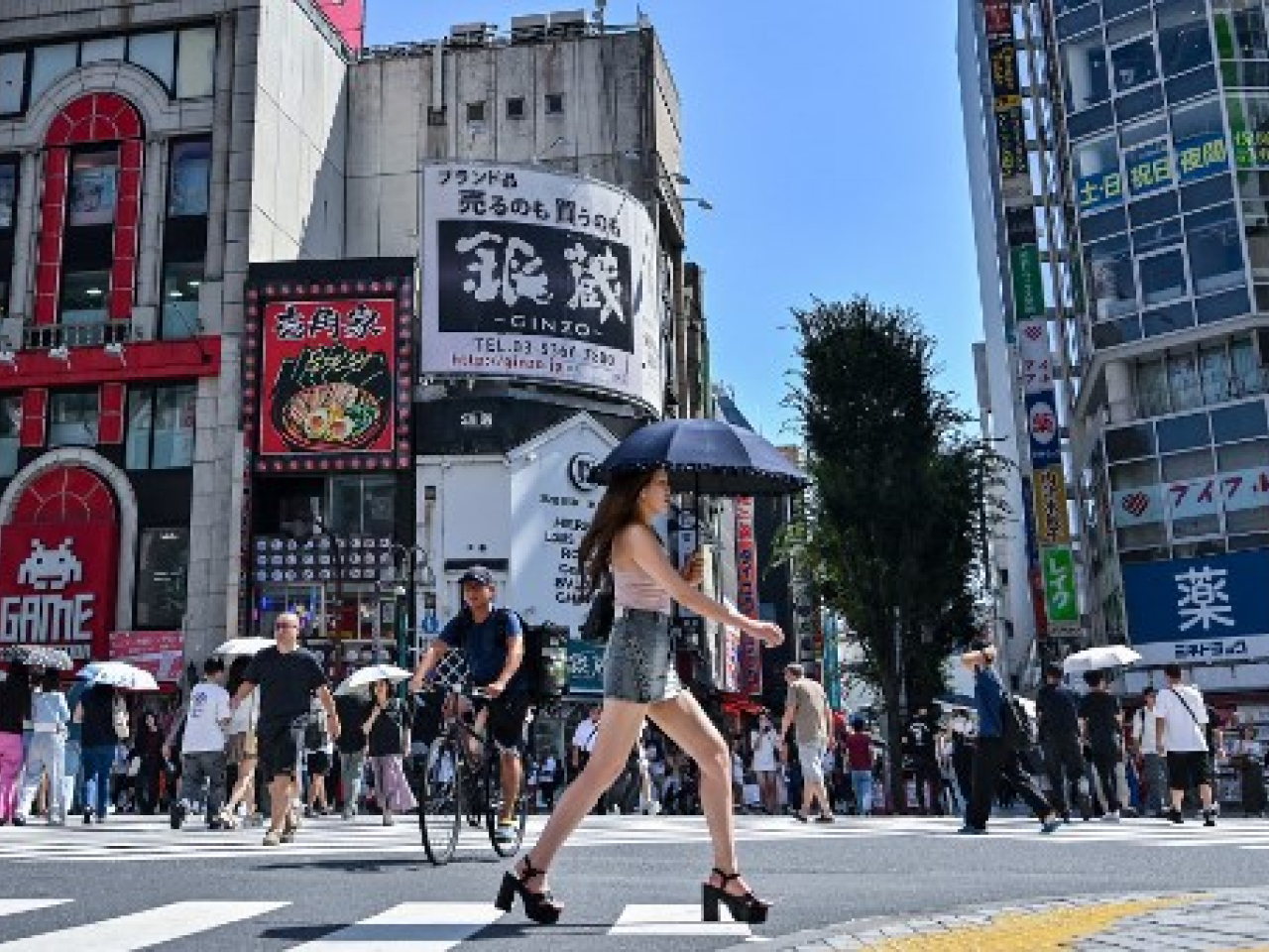 在日本東京，民眾在烈日高溫下撐傘外出。（法新社資料圖片）