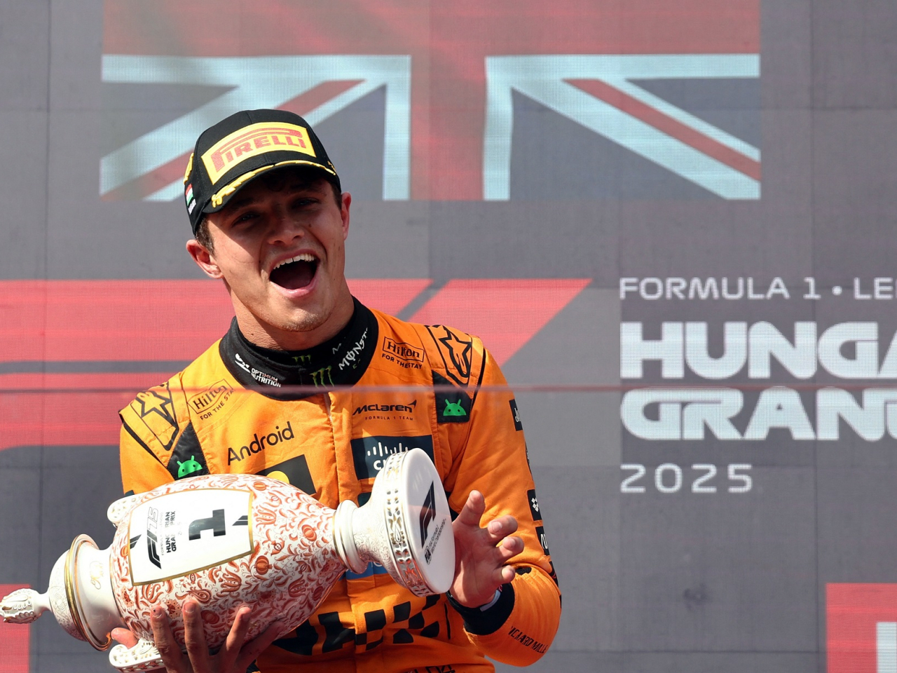 McLaren's Lando Norris celebrates on the podium with the trophy after winning the Hungarian Grand Prix. Photo: Reuters