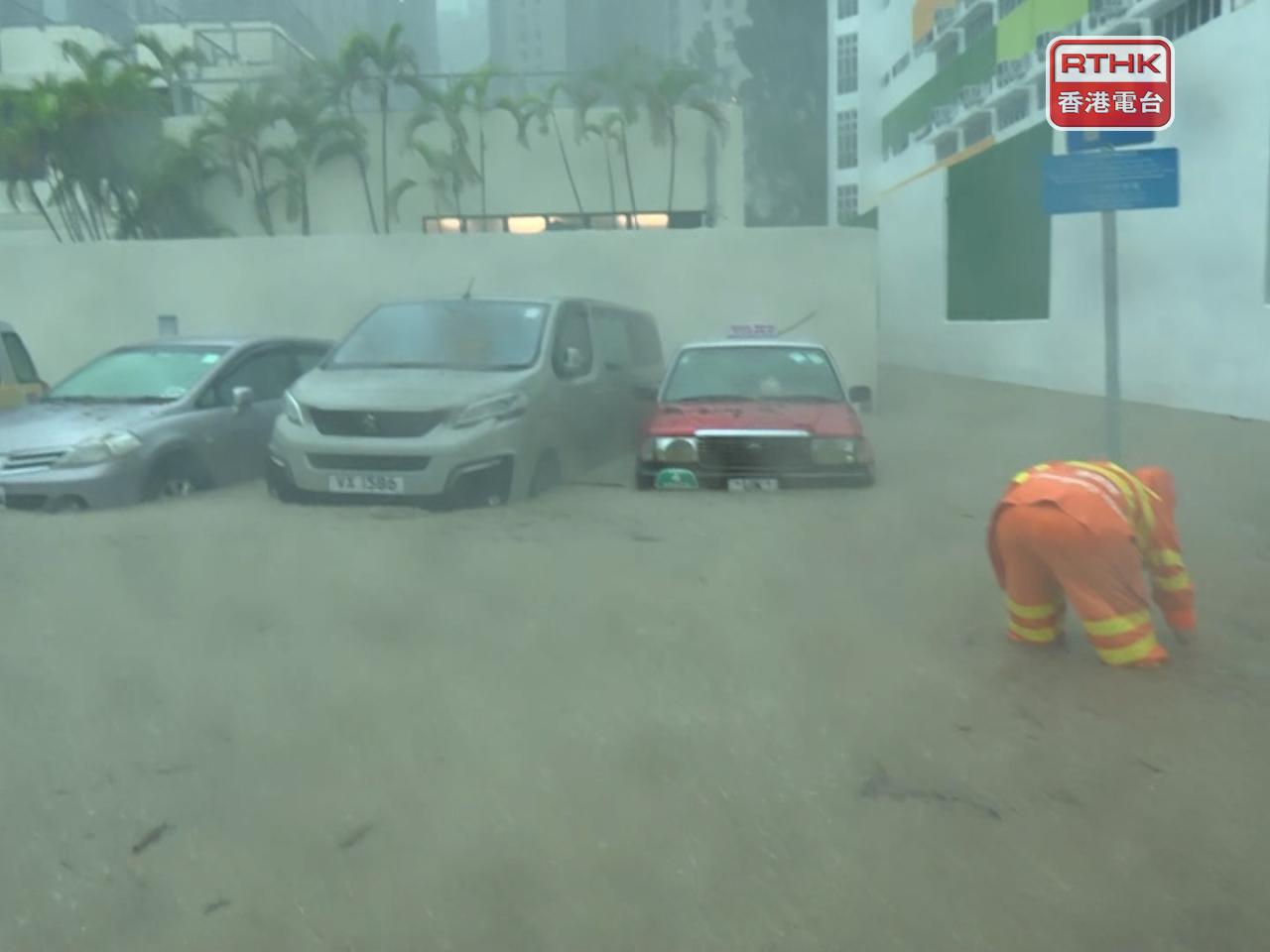Workers are seen clearing blocked drains at a flooded car park at King Yin Lane in Tseung Kwan O. Photo: RTHK