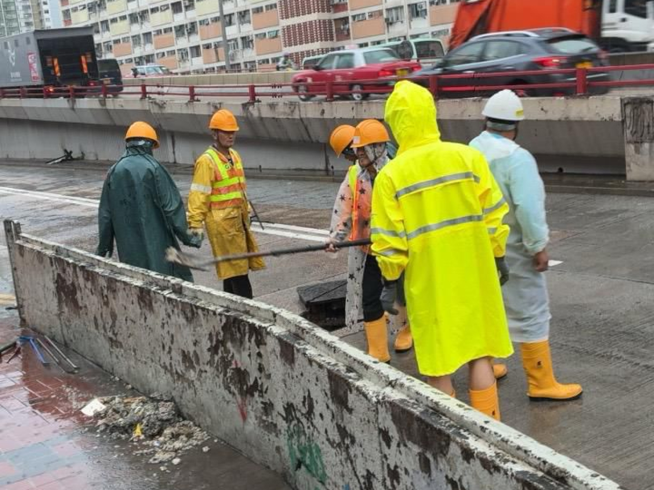 路政署人員處理龍翔道往觀塘方向近牛池灣村路面水浸。（路政署）