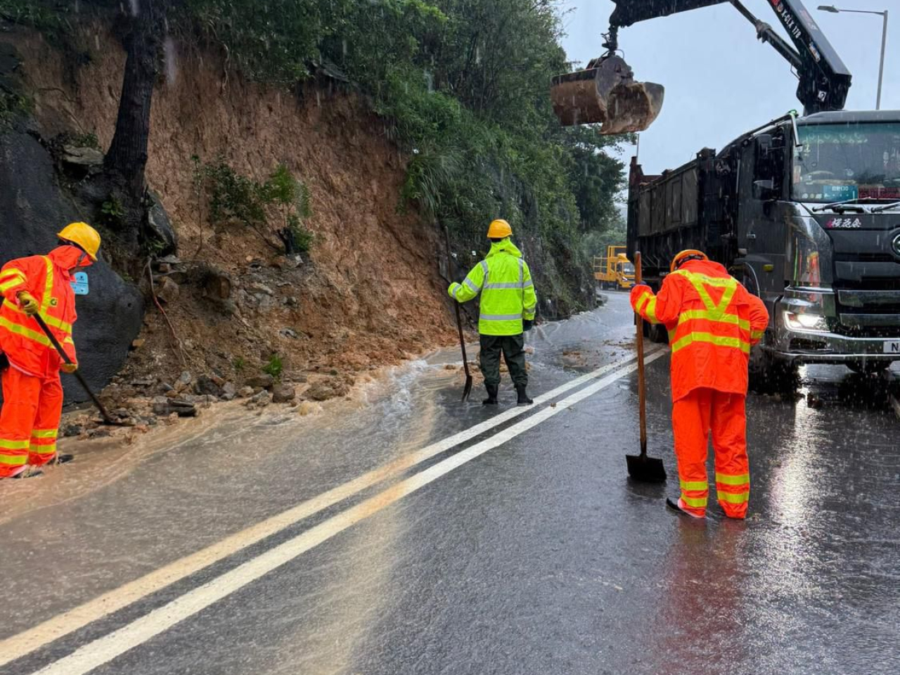 路政署承建商在大潭道山泥傾瀉現場清理路面。（路政署）