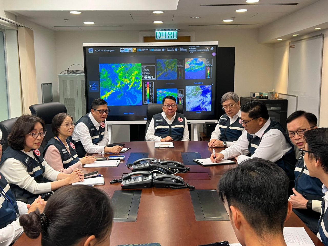 陳國基（左四）聽取司局長及部門同事匯報最新的暴雨情況及各項應變安排。（陳國基社交網頁）