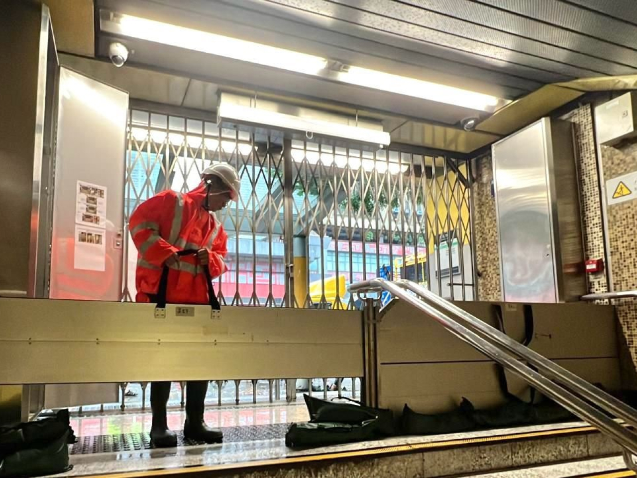 港鐵人員在車站出入口安裝防洪板。（港鐵提供）