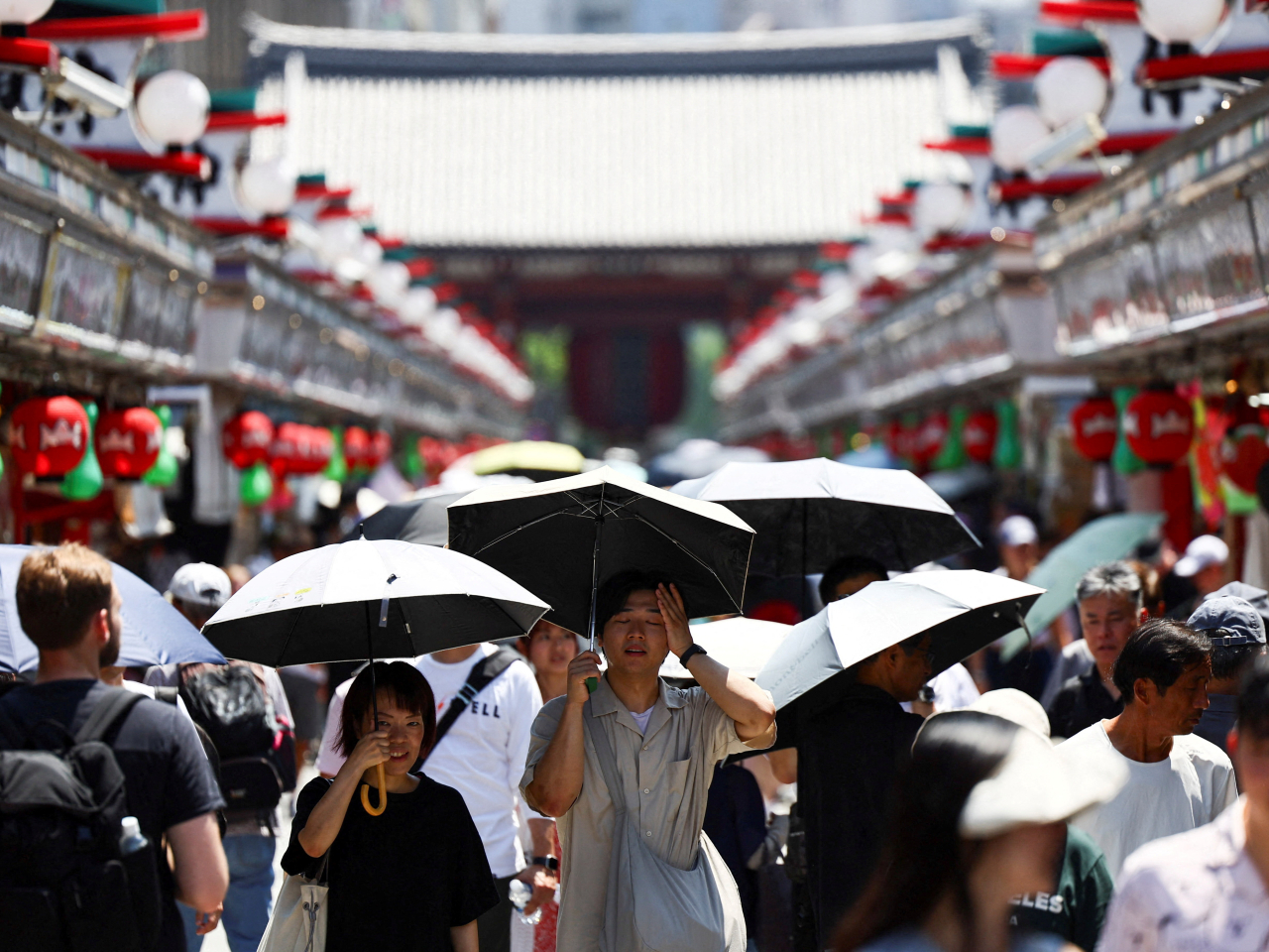 日本多處錄得高溫，在東京淺草區，遊客撐傘遮擋陽光。（路透社）