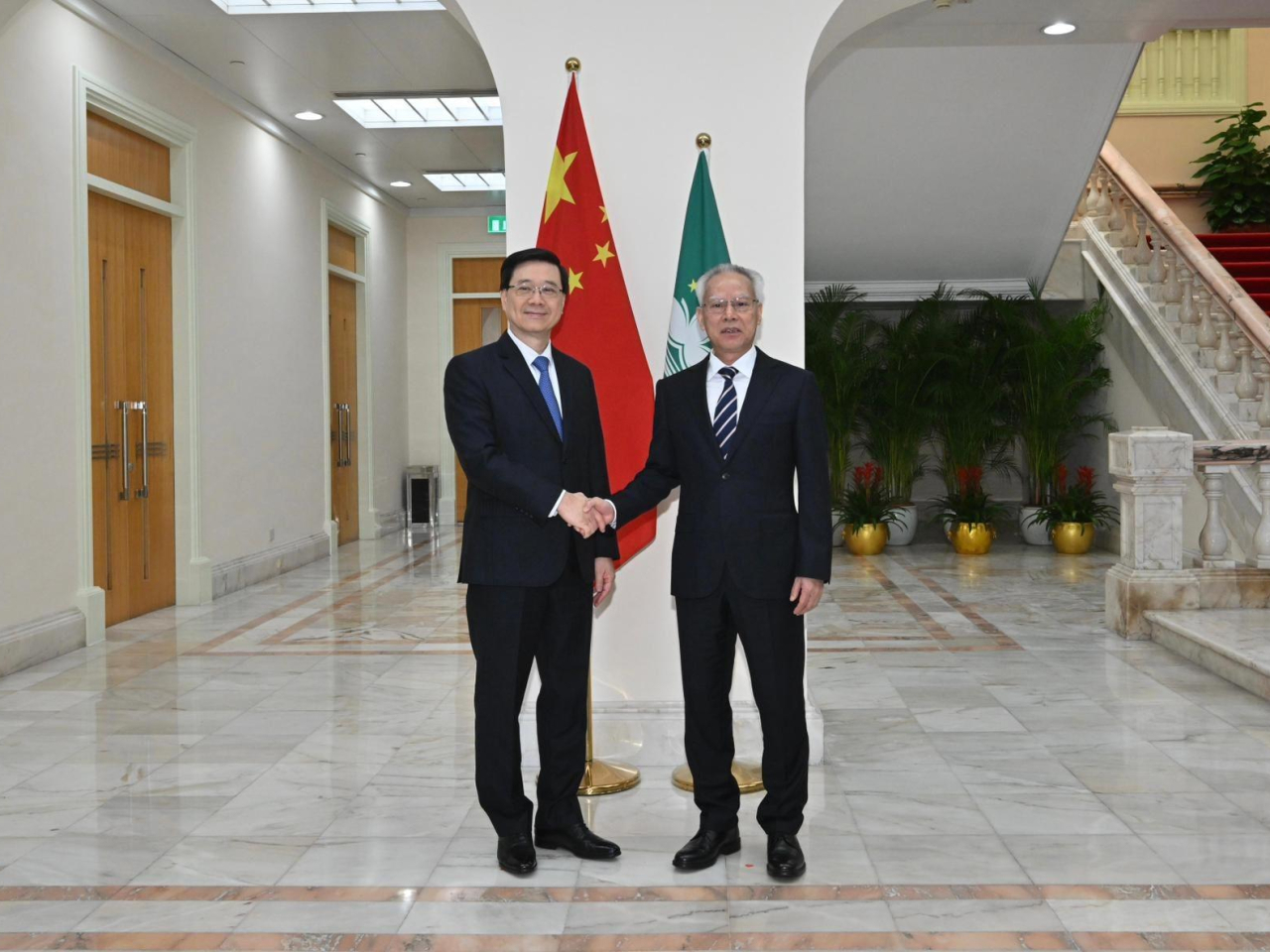 李家超（左）與澳門特區行政長官岑浩輝（右）在澳門特區政府總部合照。（政府新聞處）