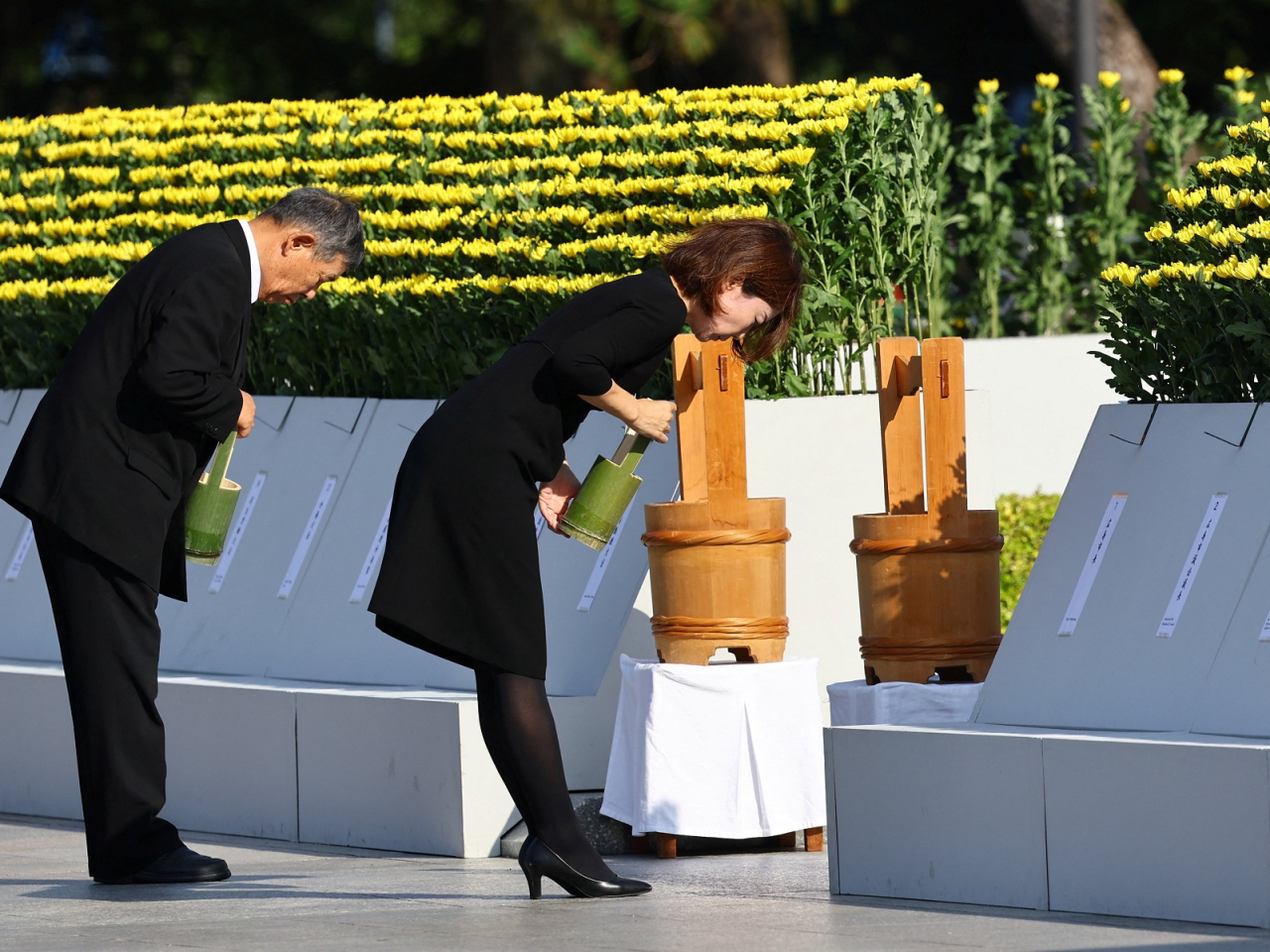 People bow after pouring water as part of a rite for the victims of the 1945 atomic bombing in Hiroshima. Photo: Reuters