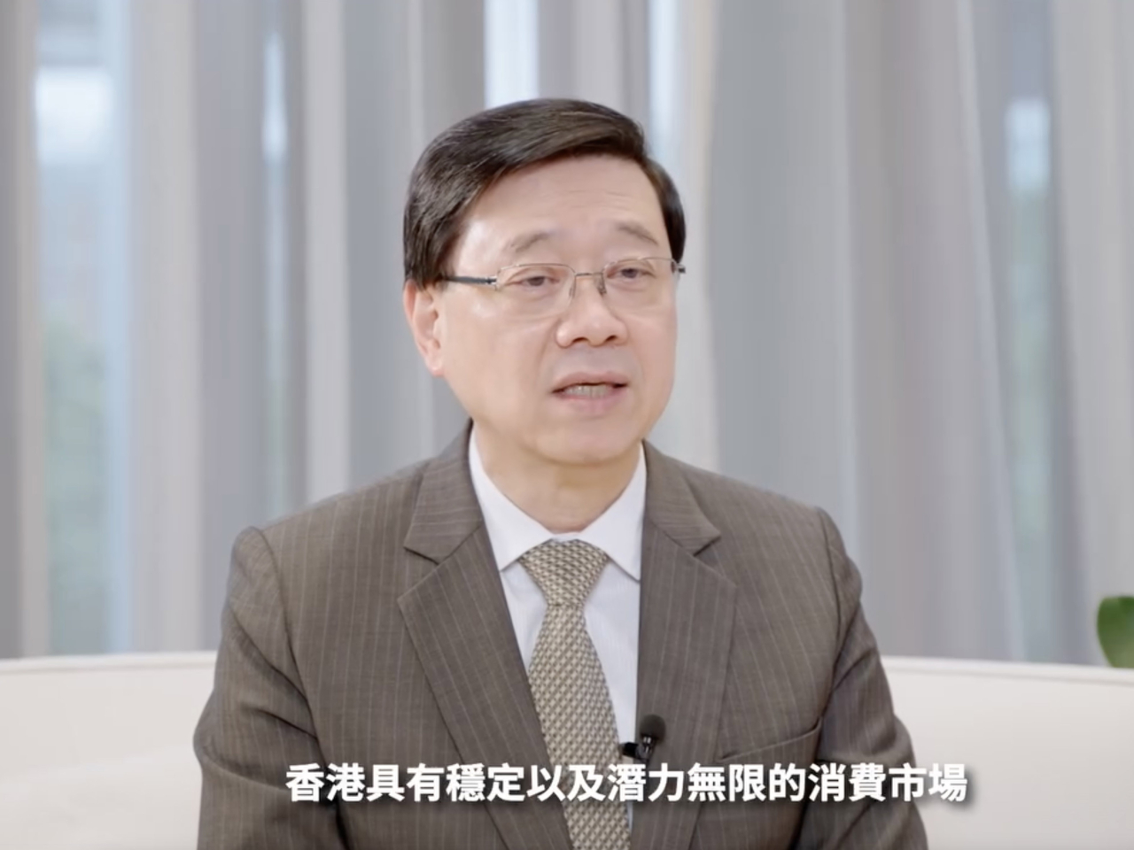李家超說，香港持續引入海內外優質企業來港落戶或擴展業務，提振本地經濟。（李家超社交專頁短片截圖）