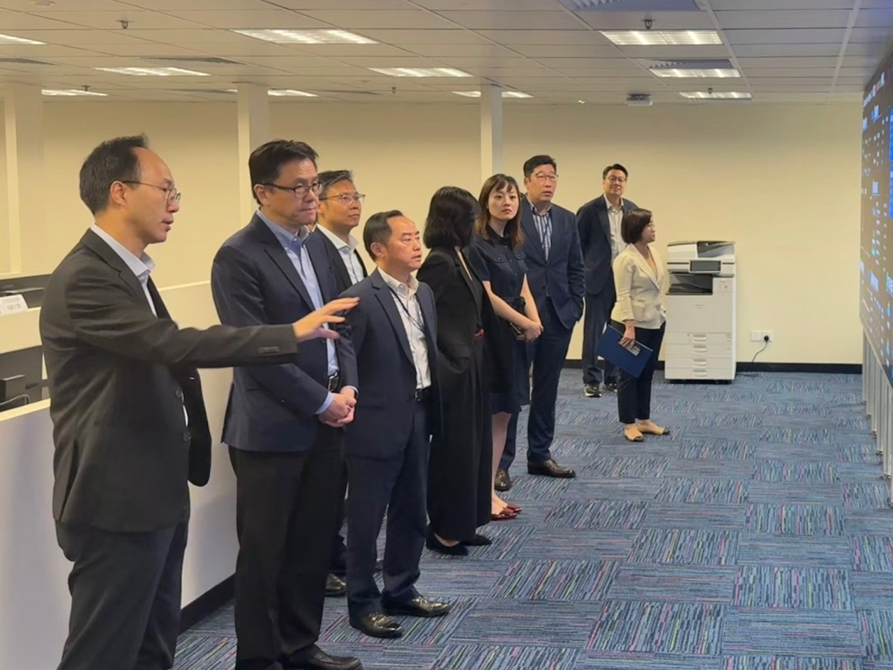 創新科技及工業局局長孫東（左二）昨日聽取數字政策辦公室工作團隊介紹​第十五屆全運會和殘特奧會香港賽區資訊系統。（政府新聞處圖片）