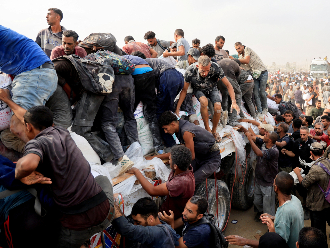 The people of Khan Younis in the southern Gaza Strip scramble to collect aid supplies from trucks entering through Israel. File photo: Reuters