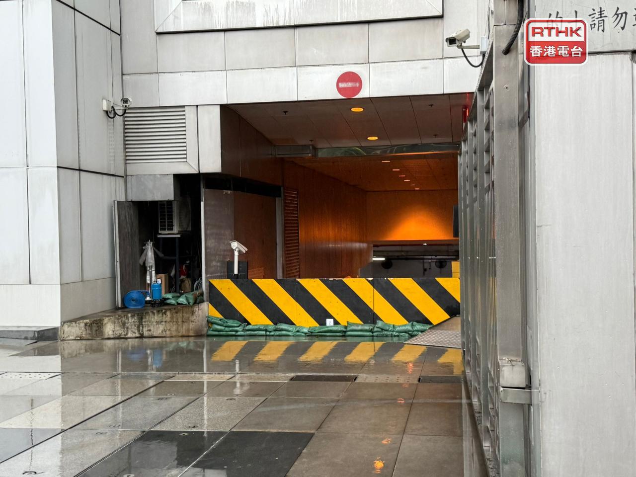 中聯辦外早上一度出現水浸，停車場有擋水板及堆放沙包。（盧紫菁攝）