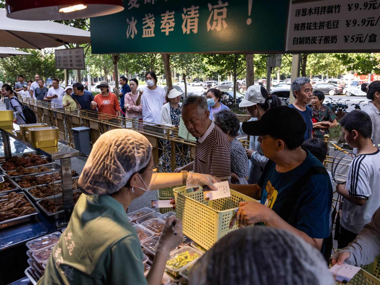 Beijing residents line up at a setup of stalls selling food to passersby next to Beiyuan Grand Hotel. Photo: Reuters
