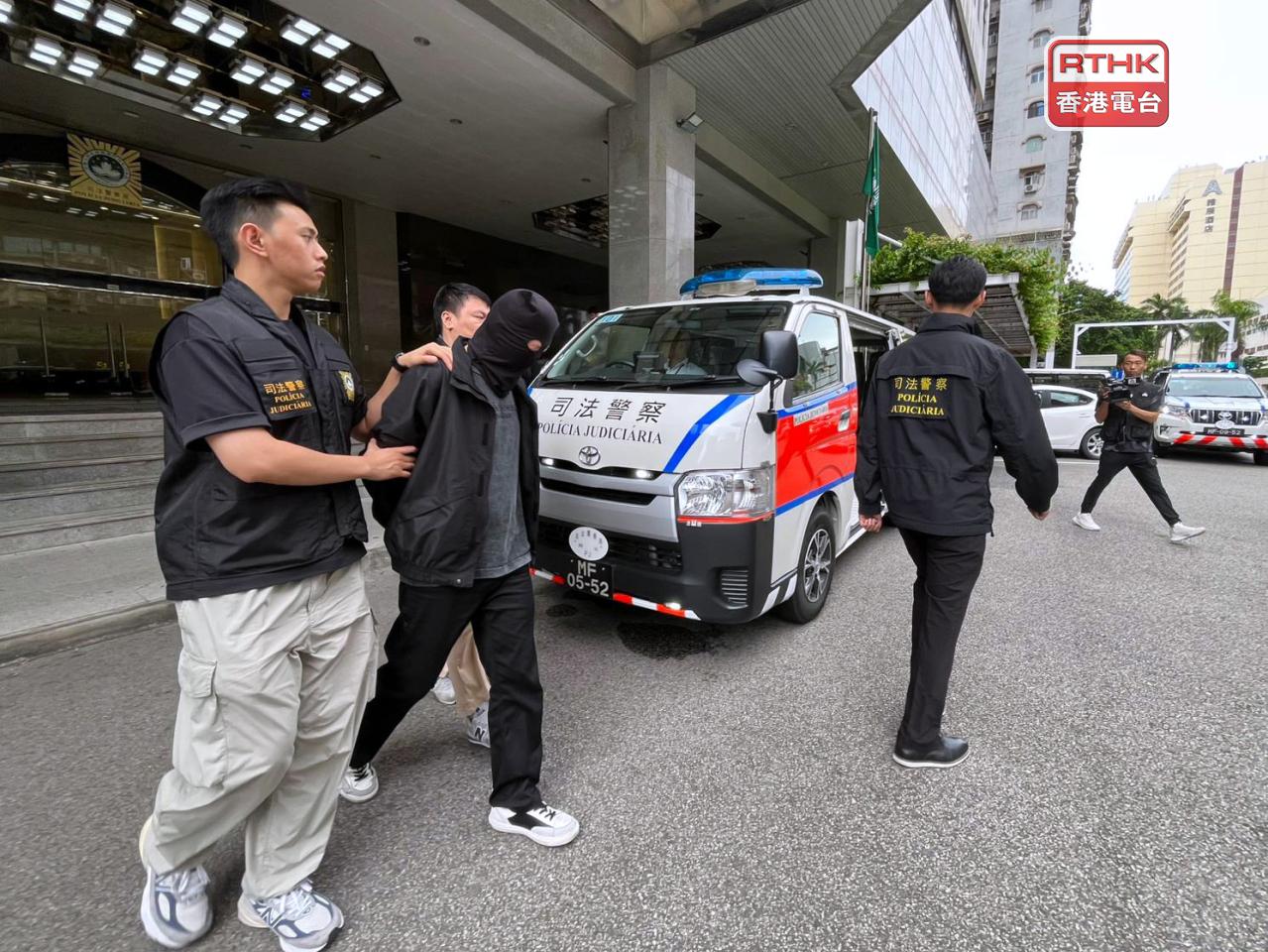 澳門在下午將涉嫌在過去一年強協助詐騙犯罪集團清洗黑錢的香港男子押往檢察院偵訊。（鄭月明攝）