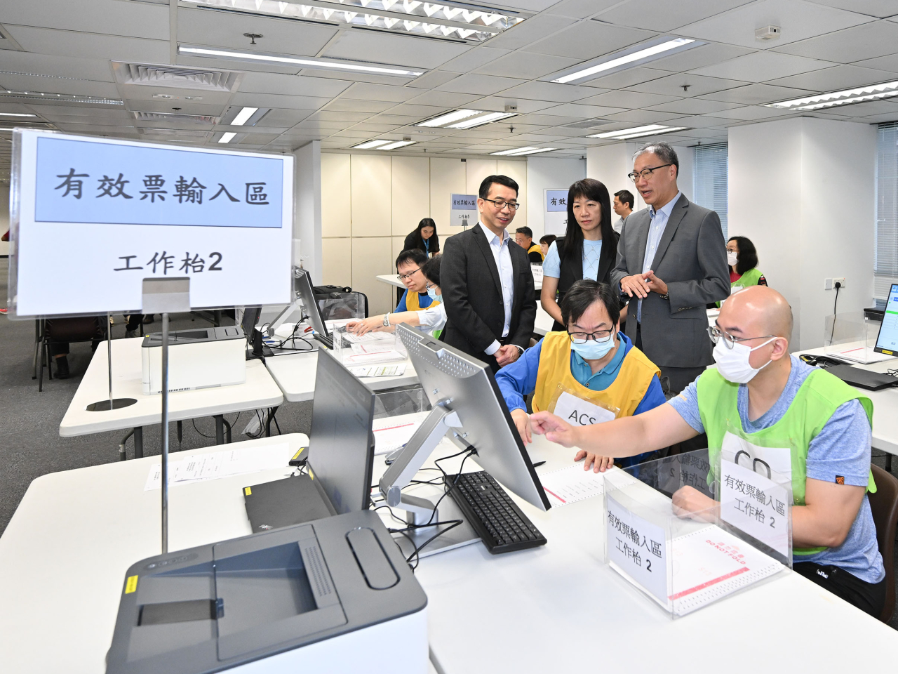 陸啟康（後排右）視察選舉事務處為中央點票站工作人員安排的實習訓練。（政府新聞處）