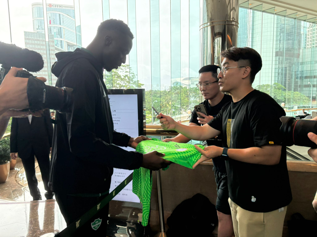A fan asks Al-Ahli goalkeeper Edouard Mendy to autograph a football jersey. Photo: RTHK