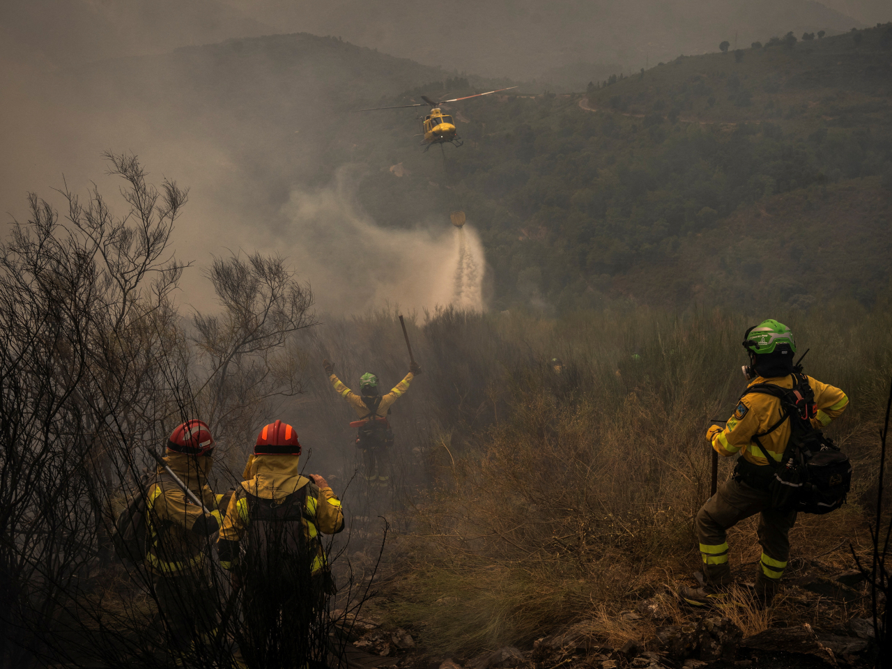 A helicopter water bombs a wildfire site in Galicia region, Spain. Photo: Reuters