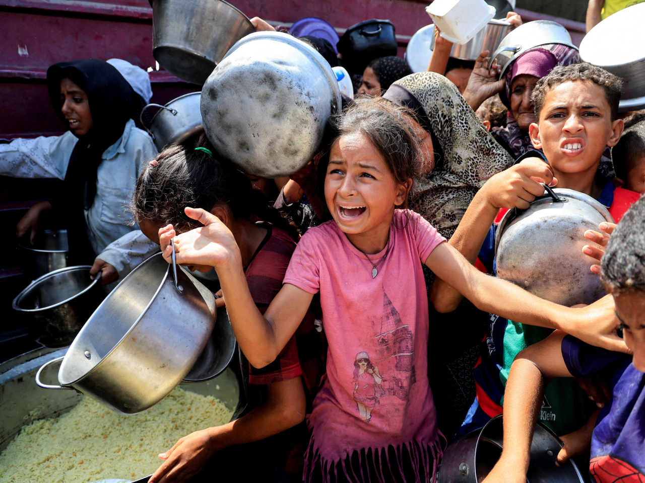 Children wait to receive food from a charity kitchen in Khan Younis on Thursday. Photo: Reuters