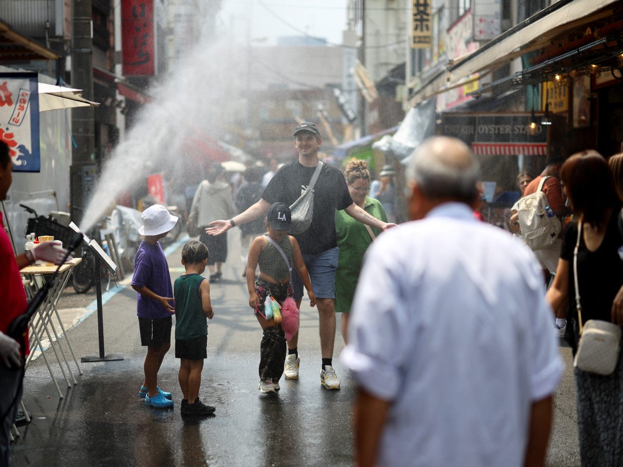 東京連續多日出現高溫天氣，有觀光景點以水霧噴灑裝置協助遊客降溫。（路透社資料圖片）