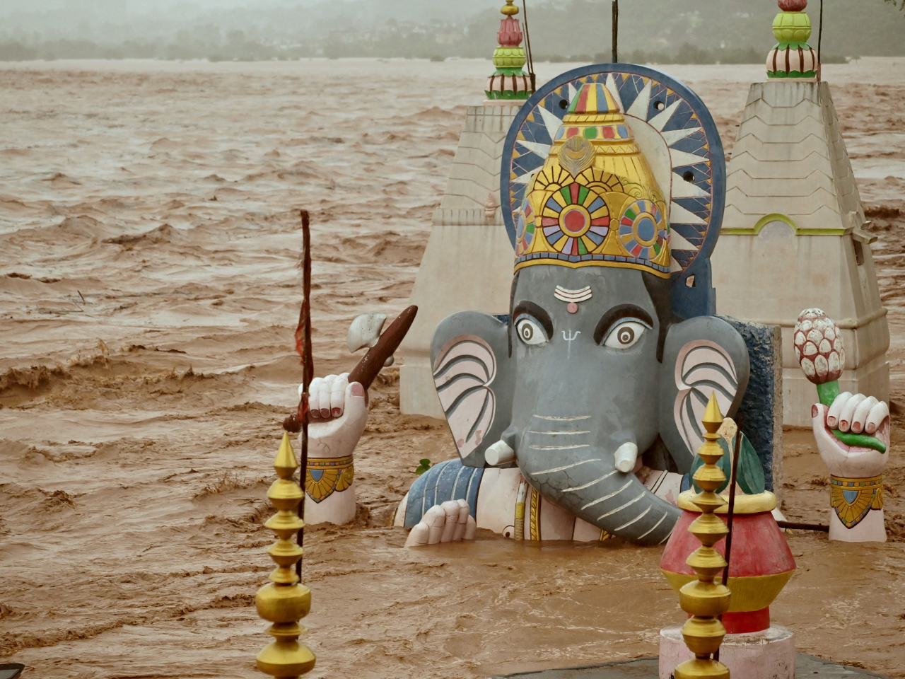 Water from an overflowing river floods a temple of the Hindu elephant god Ganesh following heavy rain in Jammu. Photo: Reuters