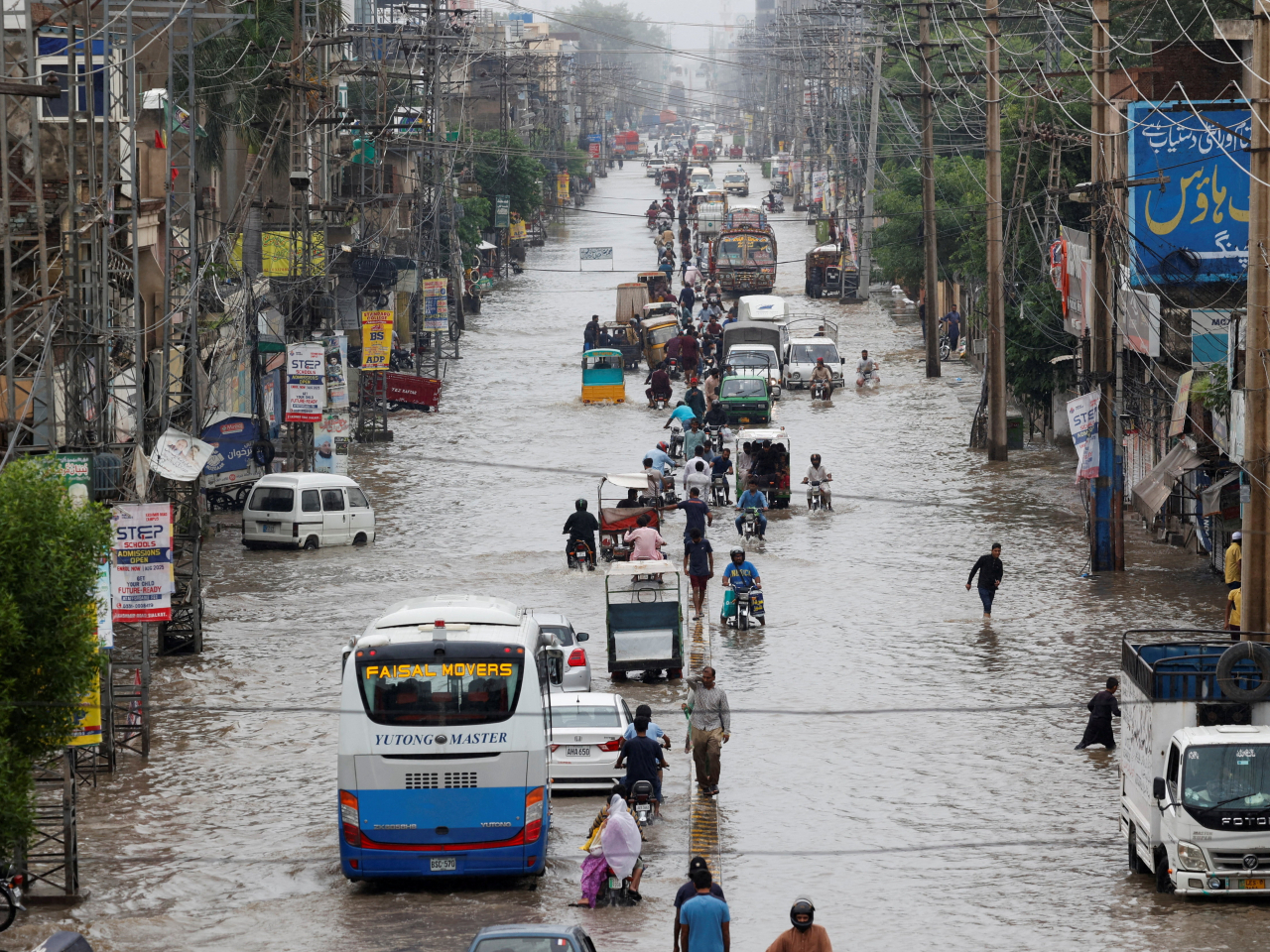 Foot and vehicular traffic on a road in Sialkot, Punjab, becomes a trudge following monsoon rains and rising water levels in Pakistan. Photo: Reuters