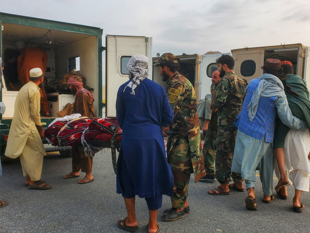 Soldiers and civilians carry earthquake victims to an ambulance at an airport in Jalalabad. Photo: Reuters