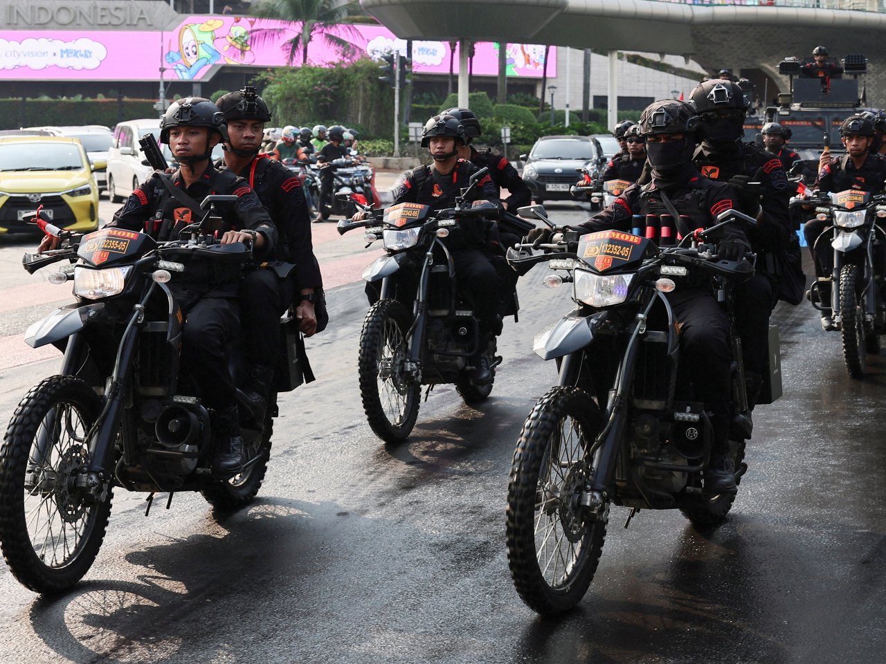 Riot police drive past the city centre in Jakarta during a patrol in a show of strength on Sunday. Photo: Reuters