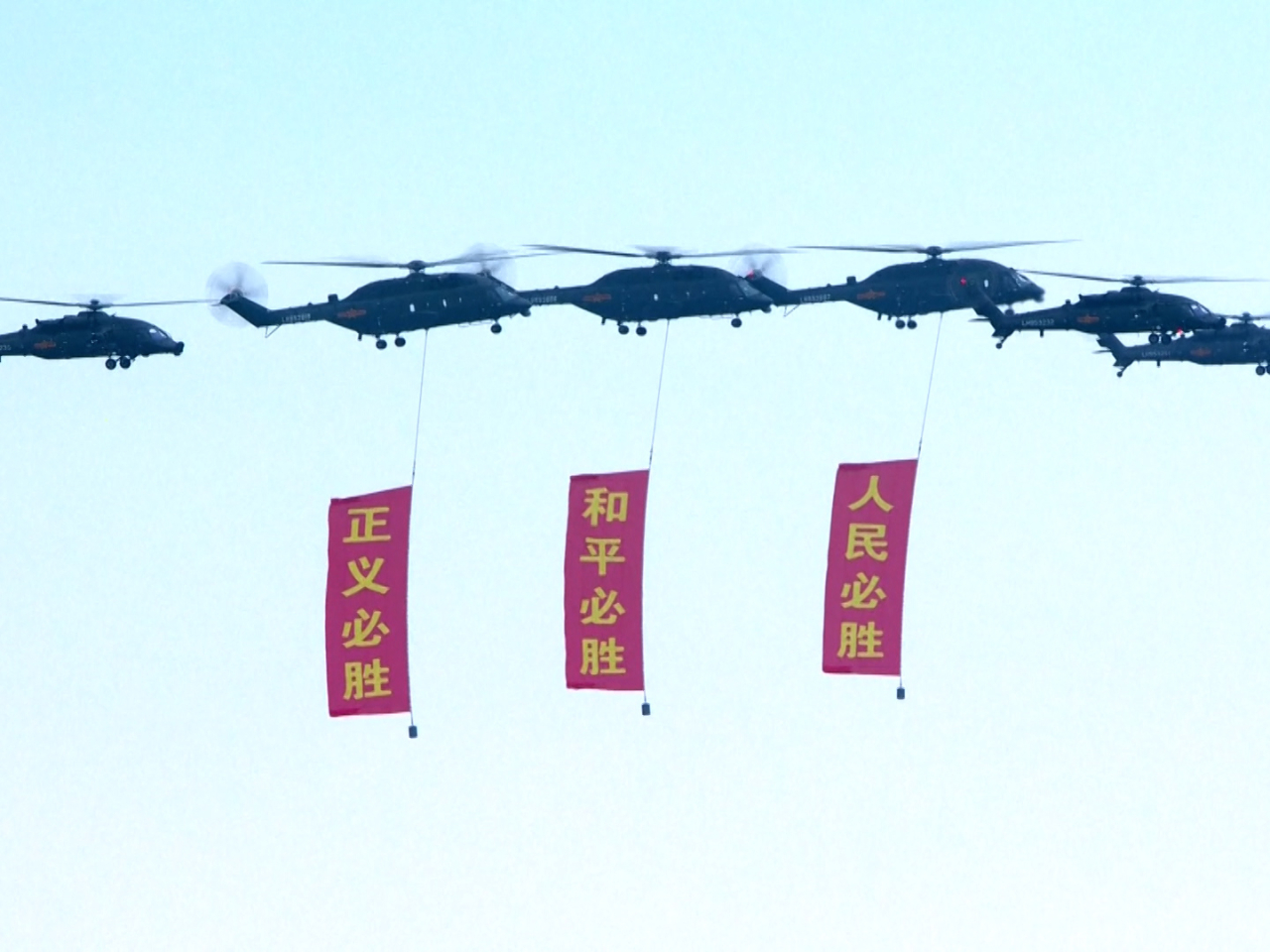 空中護旗梯隊懸掛起黨旗、國旗和軍旗，以及寫有「正義必勝、和平必勝、人民必勝」的紅旗。