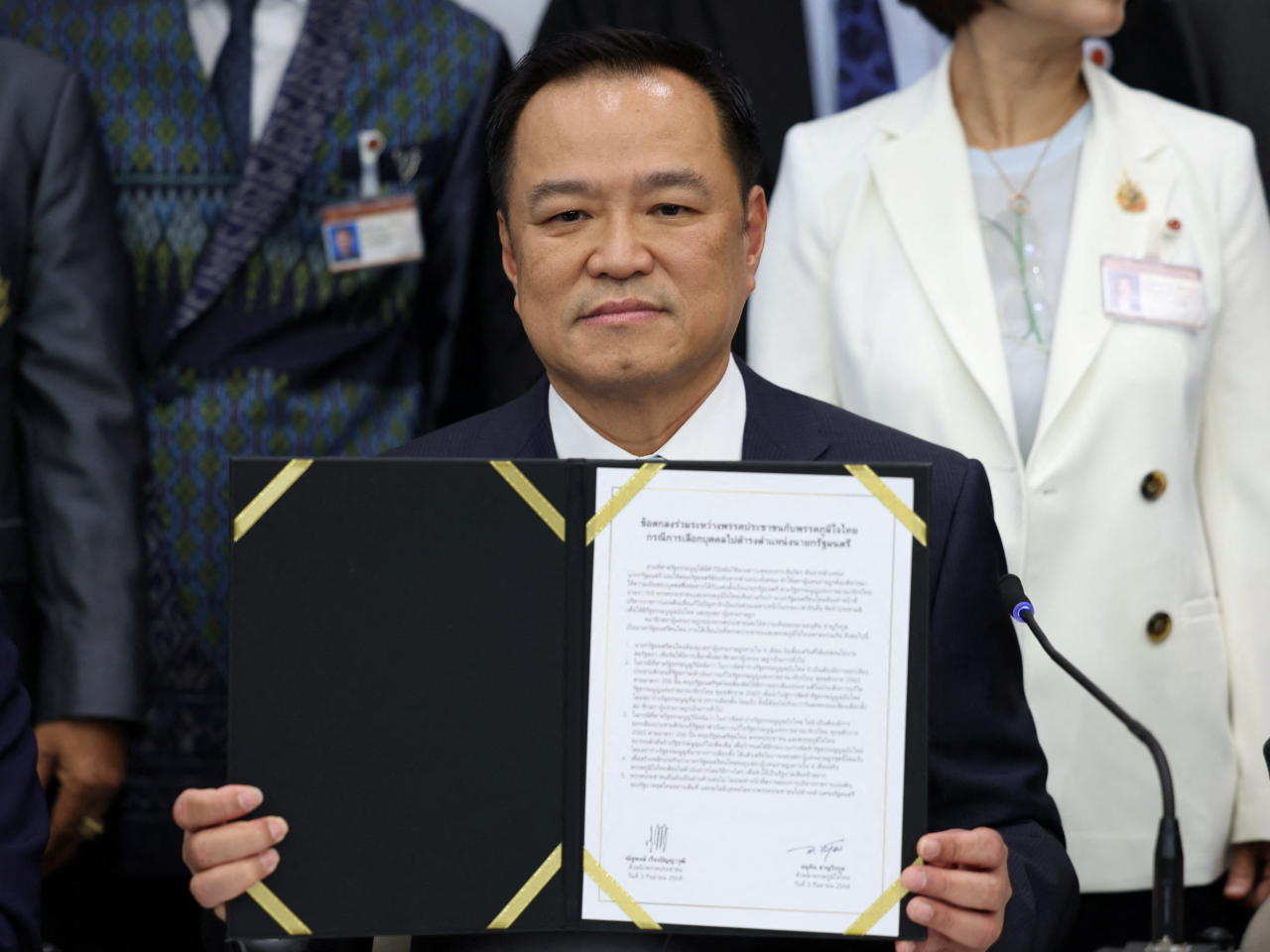 Bhumjaithai Party leader Anutin Charnvirakul holds up an agreement under which the People's Party agrees to support his bid to be prime minister. Photo: Reuters
