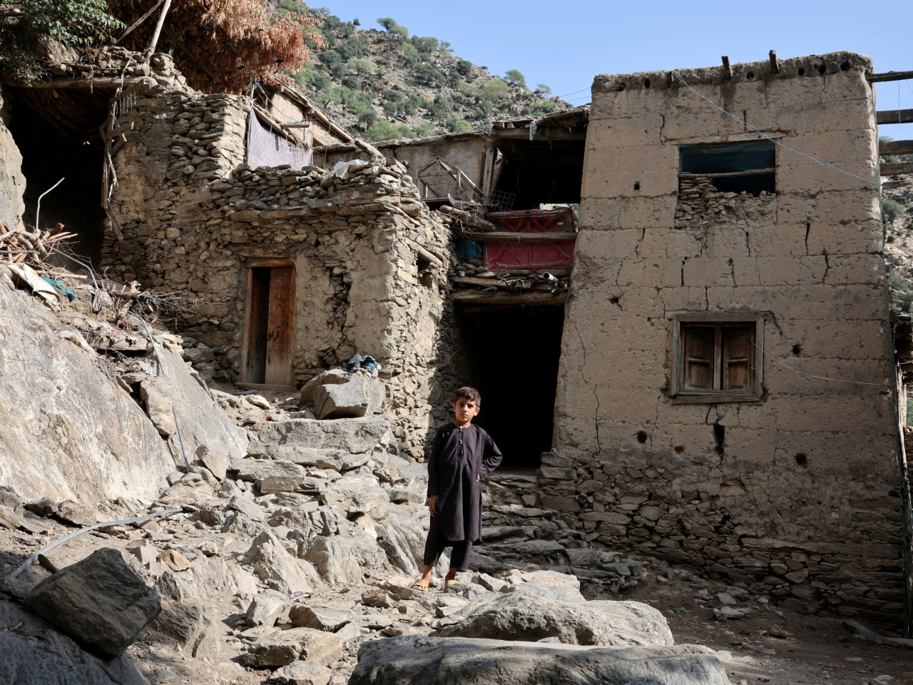 A boy stands in front of houses damaged by a deadly earthquake that struck Afghanistan's Kunar and Nangarhar provinces. Photo: Reuters