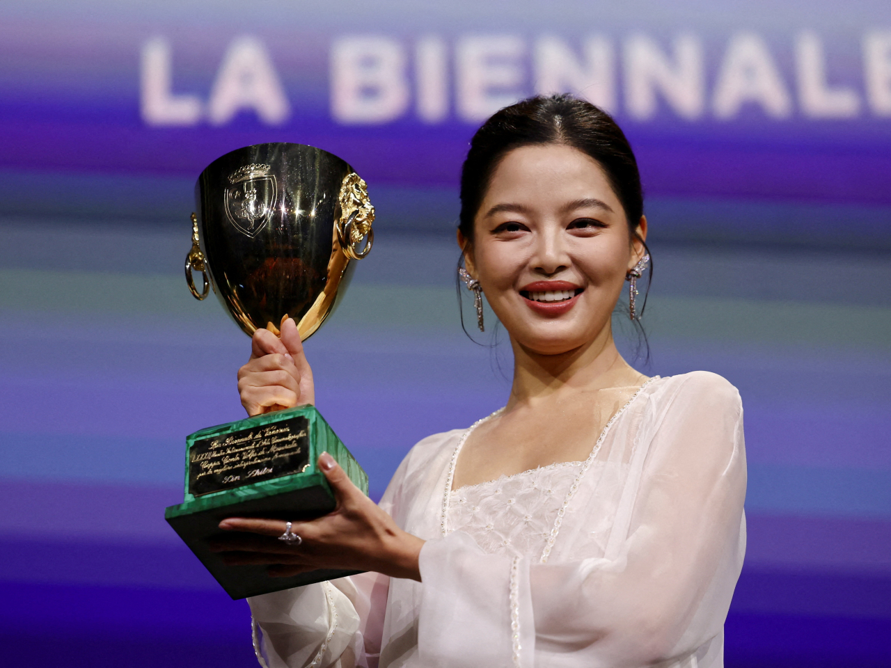 Xin Zhilei receives the Volpi Cup for Best Actress for "The Sun Rises on Us All". Photo: Reuters