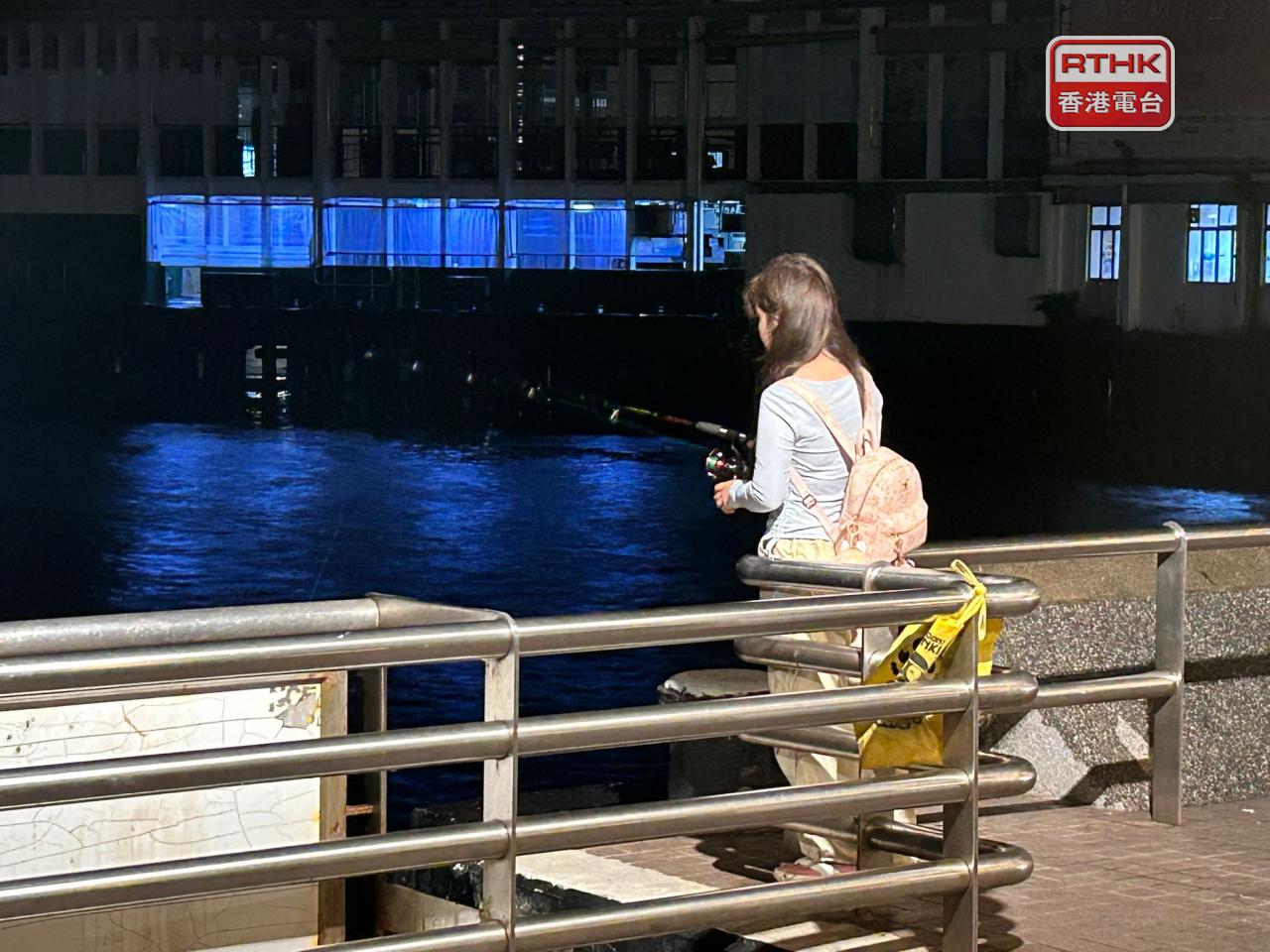 有市民凌晨時分在尖沙咀碼頭釣魚。（林漢山攝）