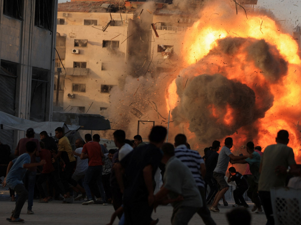 Smoke and flames rise while a residential building collapses after an Israeli air strike on Gaza City on Sunday. Photo: Reuters