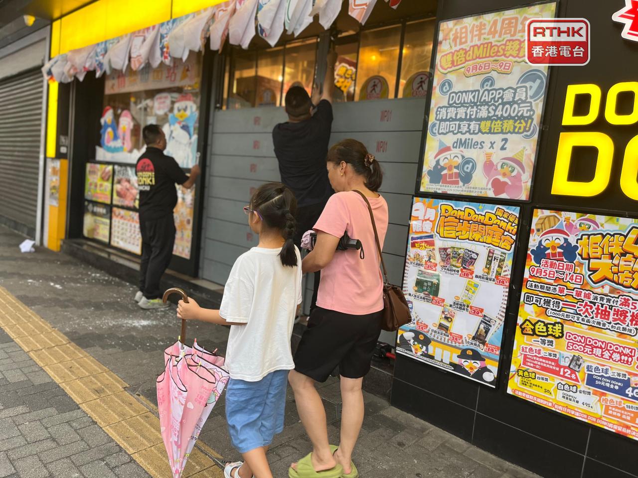 澳門有大型超市中午派員工提前拆除水閘，在改掛風球前恢復營業。(鄭月明攝)