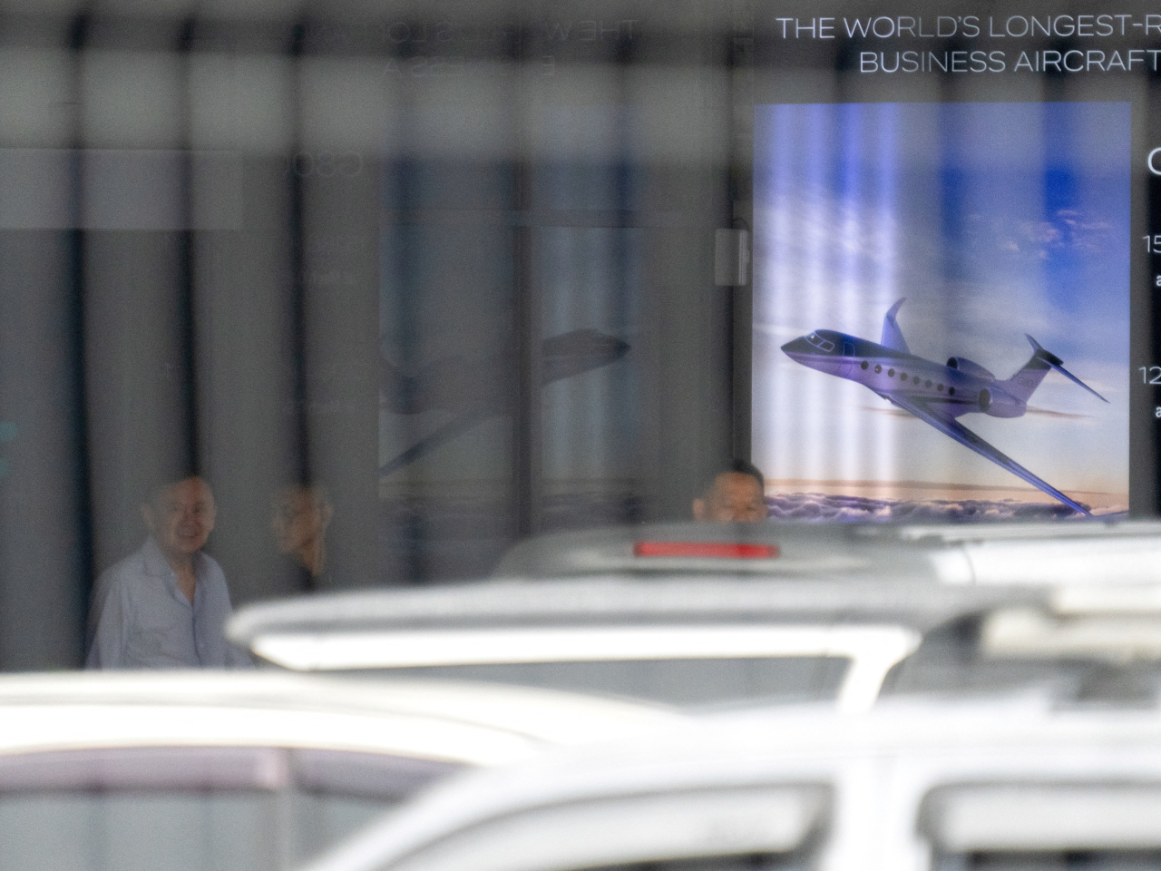 Thaksin Shinawatra can be dimly seen through a window arriving at Bangkok's Don Mueang International Airport. Photo: Reuters