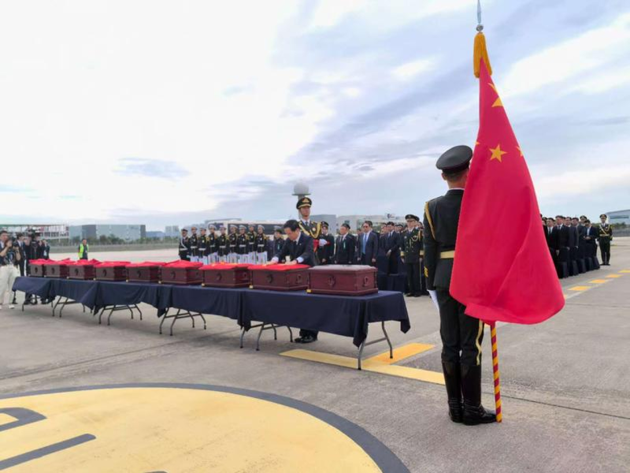 在南韓仁川，中國駐韓大使戴兵為志願軍烈士遺骸棺木覆蓋國旗。(新華社)