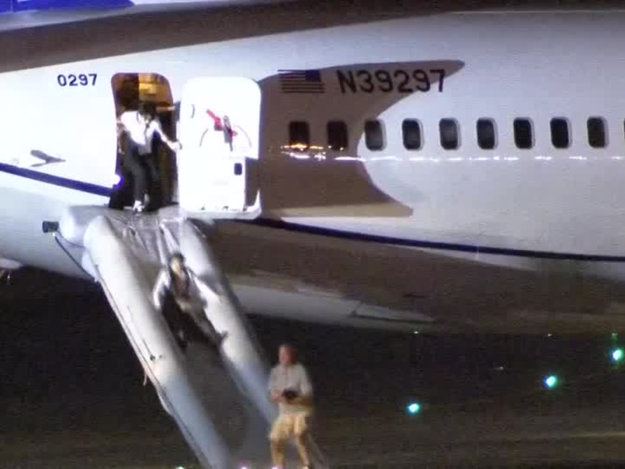 客機在關西機場緊急降落，乘客利用逃生滑梯疏散。（路透社）