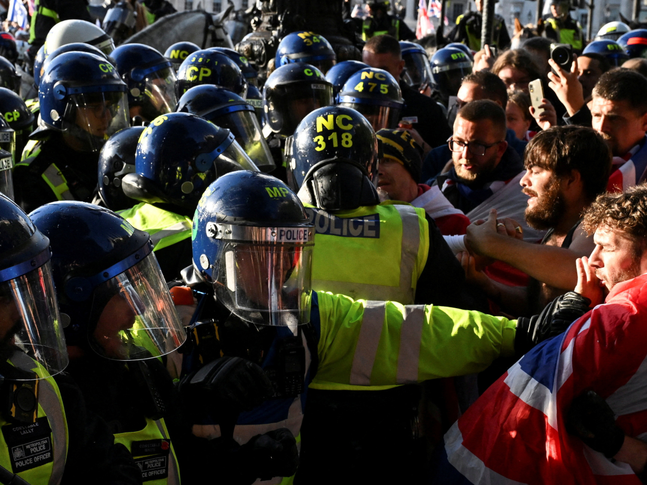 British police officers confront supporters during the anti-immigration protest in central London. Photo: Reuters