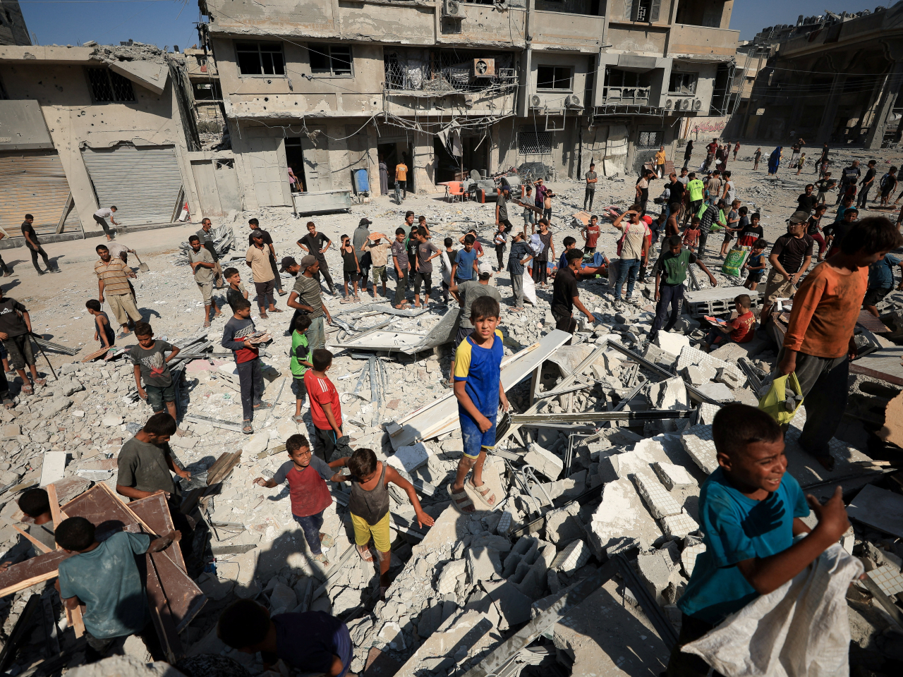 Gaza City residents scavenge for material that they can use to get through another day of their shattered lives following an Israeli airstrike on Monday. Photo: Reuters
